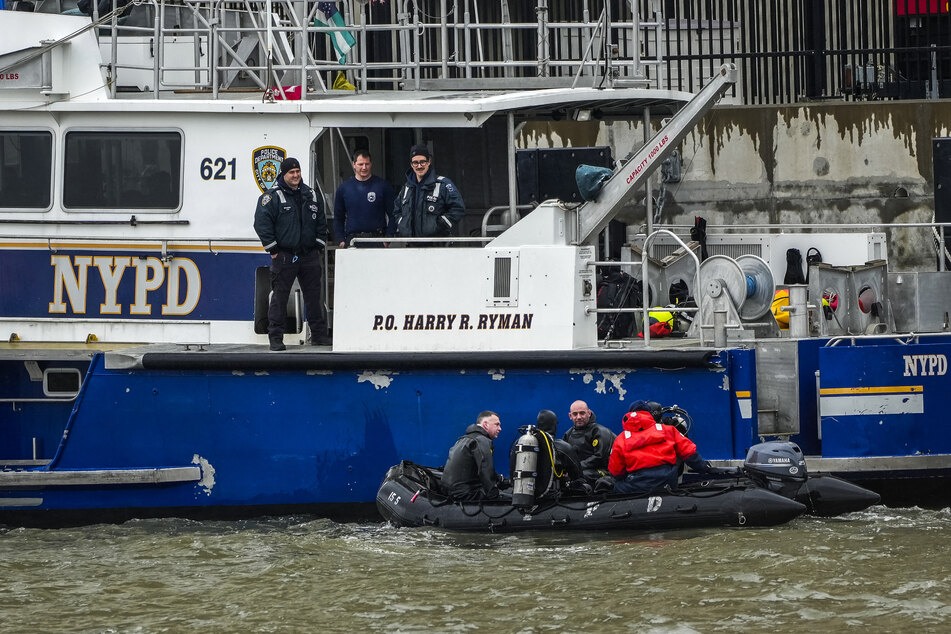 NYPD scuba divers team search next to the site of a crashed helicopter on the Hudson River on Friday in Jersey City, New Jersey.