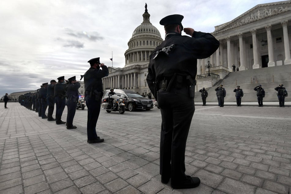 Officers salute as Officer Brian Sicknick's body departs the Capitol.