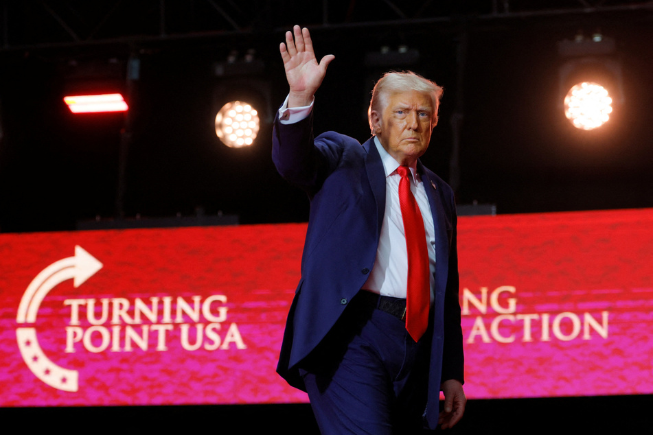 President Donald Trump waves after delivering remarks during a memorial service for Charlie Kirk at State Farm Stadium on September 21, 2025.
