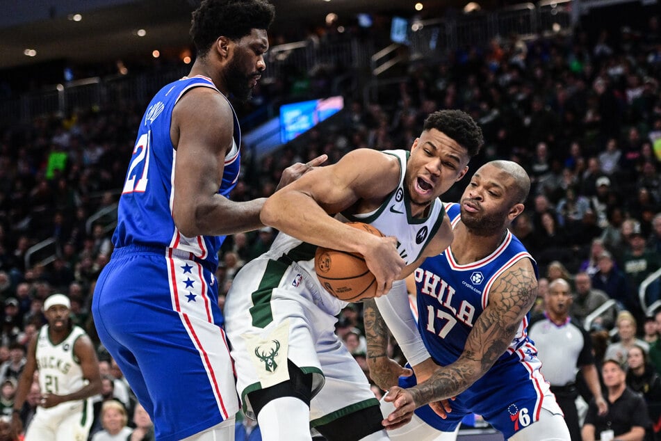 Milwaukee Bucks forward Giannis Antetokounmpo fights for the ball against Philadelphia 76ers forward P.J. Tucker and forward Joel Embiid during the first quarter at Fiserv Forum.