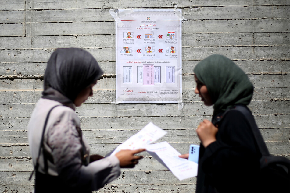 Women read instructions to voters ahead of the upcoming municipal elections in Deir el-Balah in the central Gaza Strip on April 21, 2026.