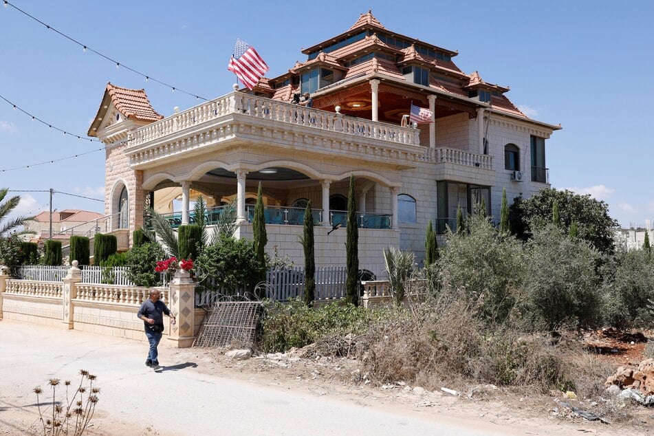 The US flag flutters as a resident walks past the home where the Ambassador Mike Huckabee paid a visit to a Palestinian-American resident of Turmus Ayya on September 5, 2026.