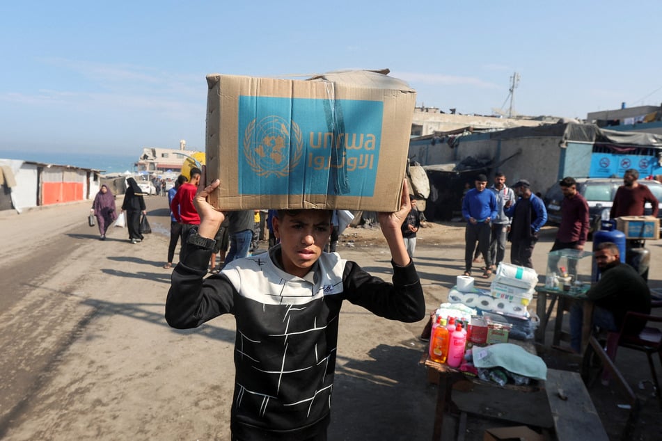 A Palestinian person carries an aid box distributed by UNRWA in Deir Al-Balah in the central Gaza Strip.