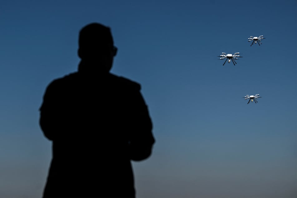 A man watches remotely operated aerial vehicles flying overhead during the NATO REPMUS 22 exercize in September, 2022.