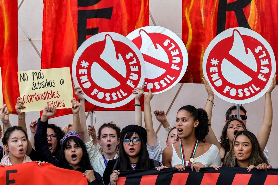 Youth activists raise placards during a protest against fossil fuels during the United Nations Climate Change Conference (COP28) in Dubai on December 12, 2023.