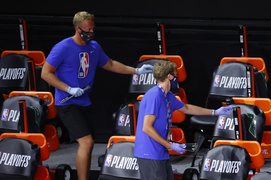 Employees remove cards bearing the players' names from chairs at Amway Center.