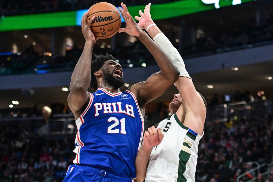 Philadelphia 76ers forward Joel Embiid takes a shot against Milwaukee Bucks center Brook Lopez in the third quarter at Fiserv Forum.