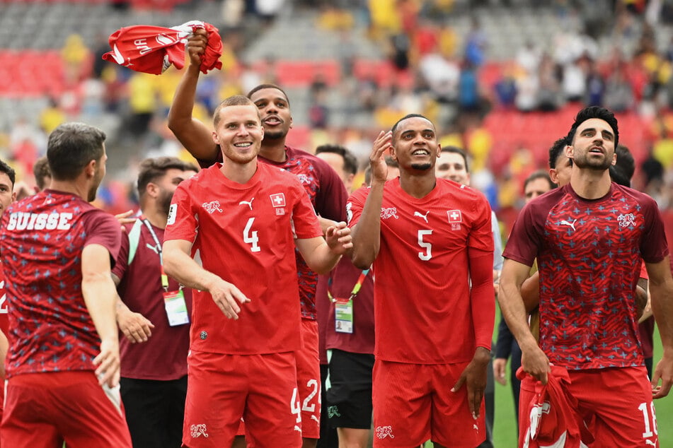 Nico Elvedi, Manuel Akanji, and Eray Comert celebrate after the penalty shootout as Switzerland qualify for the quarterfinals of the World Cup.