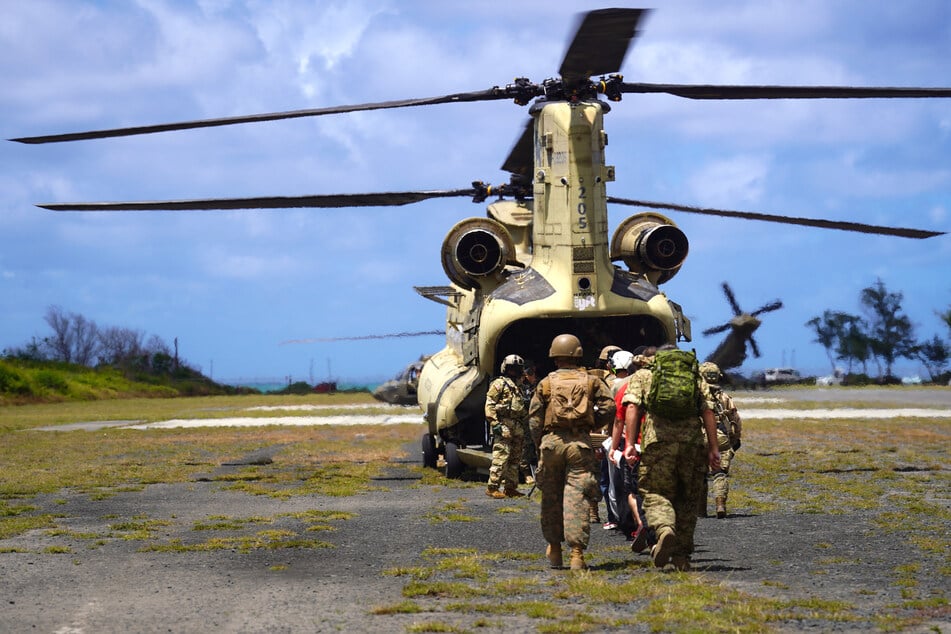 In late July, US Marines transport a simulated casualty into a transport helicopter during military exercises in Hawaii.