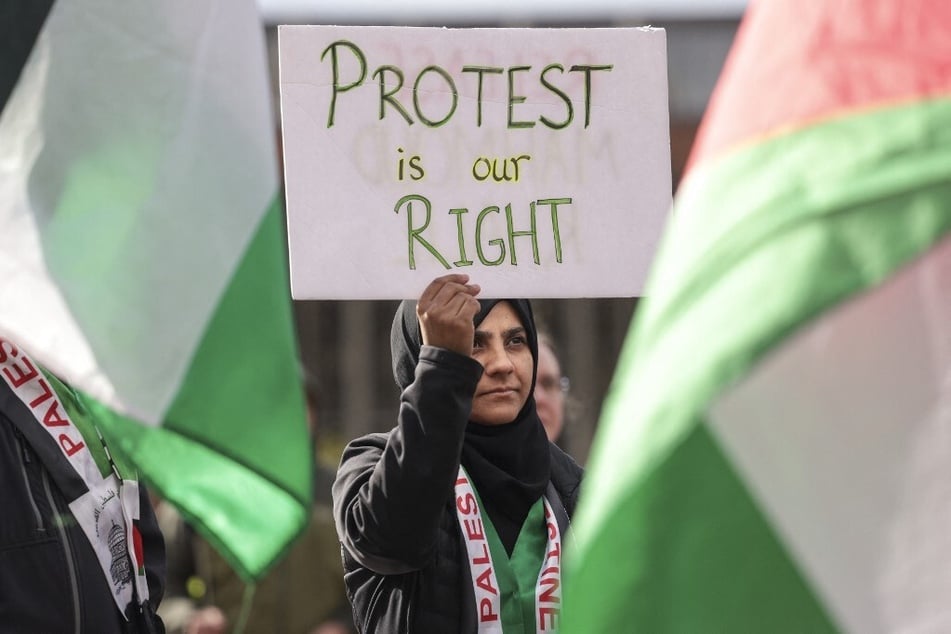 A demonstrator holds a sign reading "Protest Is Our Right" following the arrest of Columbia University activist Mahmoud Khalil during a rally at the University of Washington campus in Seattle.