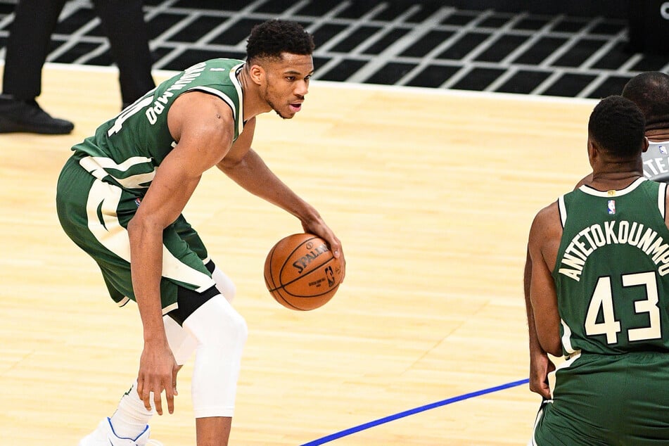 Bucks forward Giannis Antetokounmpo (l.) scored 32 points in Milwaukee's opening night win on Tuesday night.