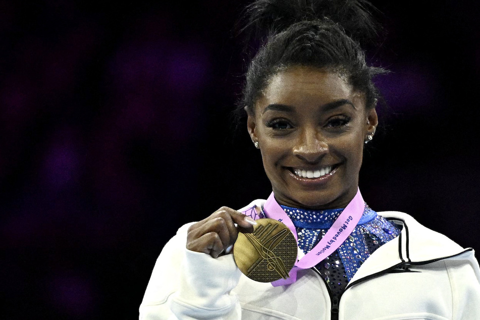 Simone Biles celebrates on the podium after the Women's Individual All-Around Final during the 52nd FIG Artistic Gymnastics World Championships in Antwerp, Belgium.