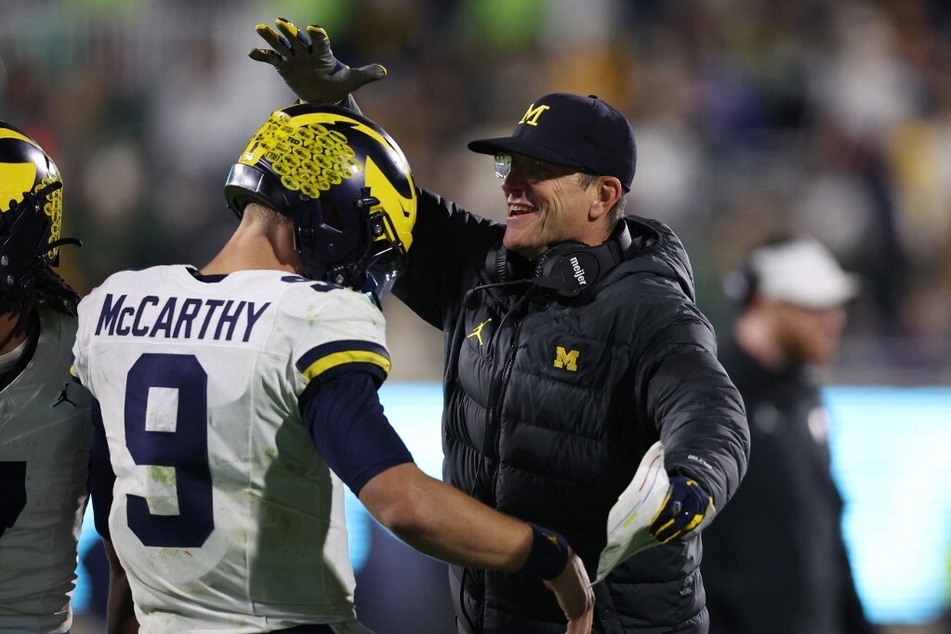 Michigan head coach Jim Harbaugh (r) has denied knowledge of the alleged sign-stealing.