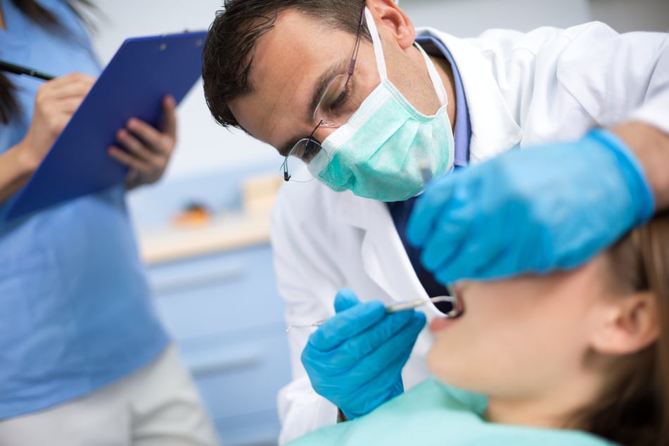 A dentist checks his patient's teeth (stock image).