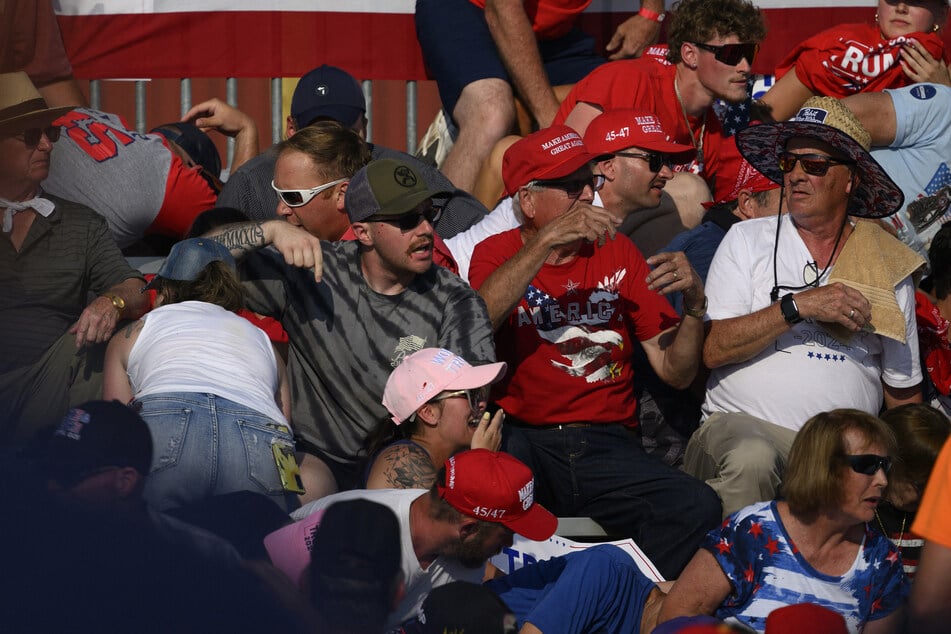 Attendees call for aid moments after Thomas Matthew Crooks opened fire at Donald Trump during a campaign rally in Butler, Pennsylvania, on July 13, 2024. Rallygoer Jim Copenhaver has reportedly died from complications after getting shot during the event.