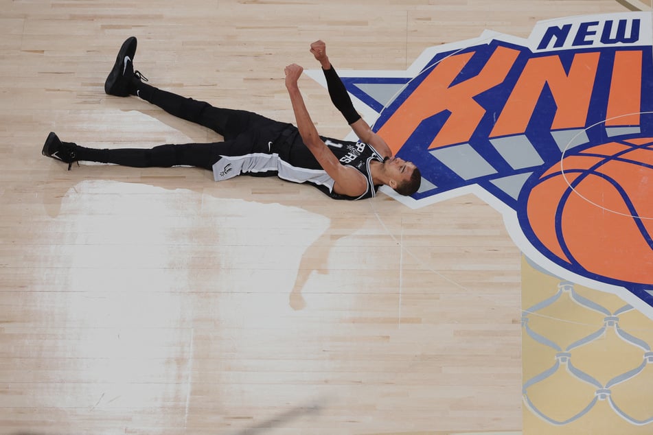 San Antonio Spurs forward Victor Wembanyama lies on the court and reacts against the New York Knicks during game three of the 2026 NBA Finals in the fourth quarter at Madison Square Garden.