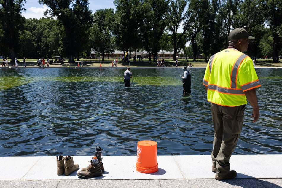 National Park Service workers and contractors use vacuums to remove algae from the bottom of the Lincoln Memorial Reflecting Pool on June 20, 2026.