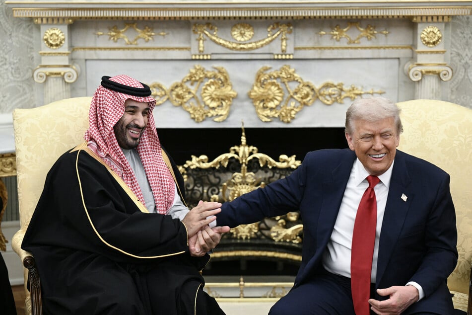 President Donald Trump (R) jokes about hand shakes and fist pumps with Crown Prince and Prime Minister of the Kingdom of Saudi Arabia Mohammed bin Salman (L) during a meeting in the Oval Office of the White House in Washington, DC on November 18, 2025.