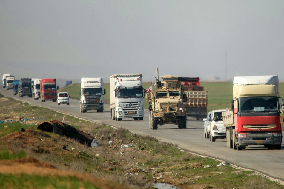 A US military mine-resistant ambush protected (MRAP) armoured fighting vehicle moves in a convoy with other trucks transporting military equipment along a highway outside Qamishli in Syria's northeastern Hasakah province on Monday.