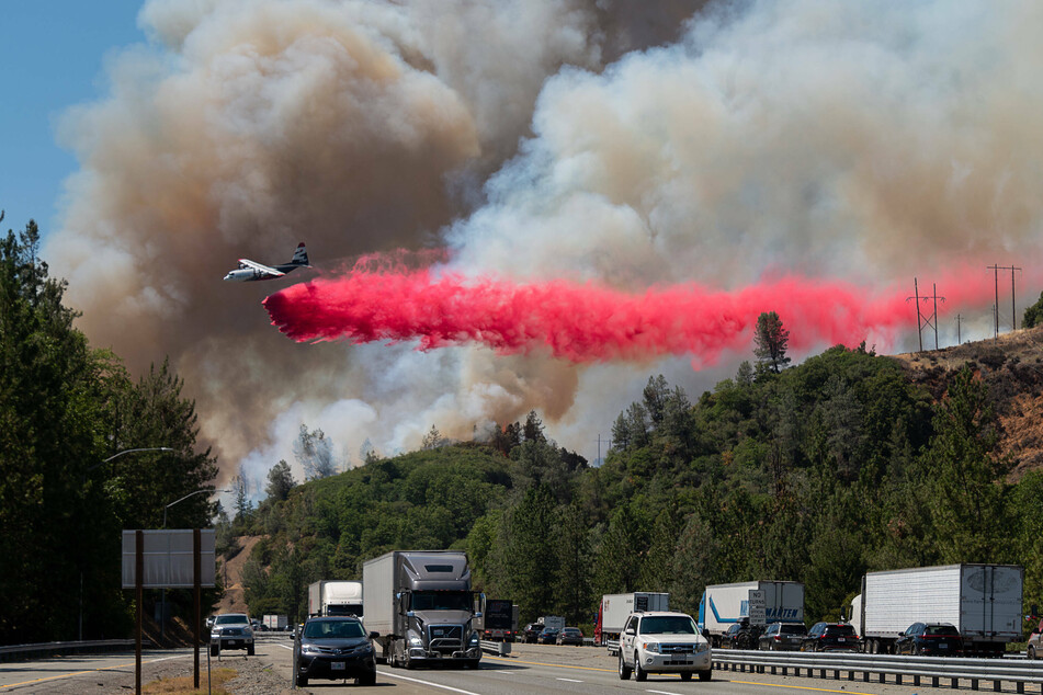An air-tanker drops fire retardant on the Salt fire near the northbound I-5 freeway.