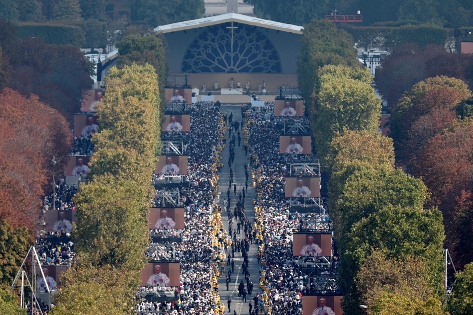 Hundreds of thousands of worshippers watch giant screens along Champs-Elysees Avenue broadcasting Pope Leo XIV celebrating a solemn outdoor mass in Paris on September 26, 2026.