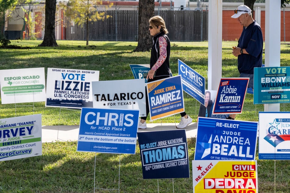 People depart a polling location on the first day of early voting in Texas for the midterm elections, at the West Gray Metropolitan Multiservice Center in Houston, Texas, on October 19. The elections have been plagued by multiple scandals involving fake polls.