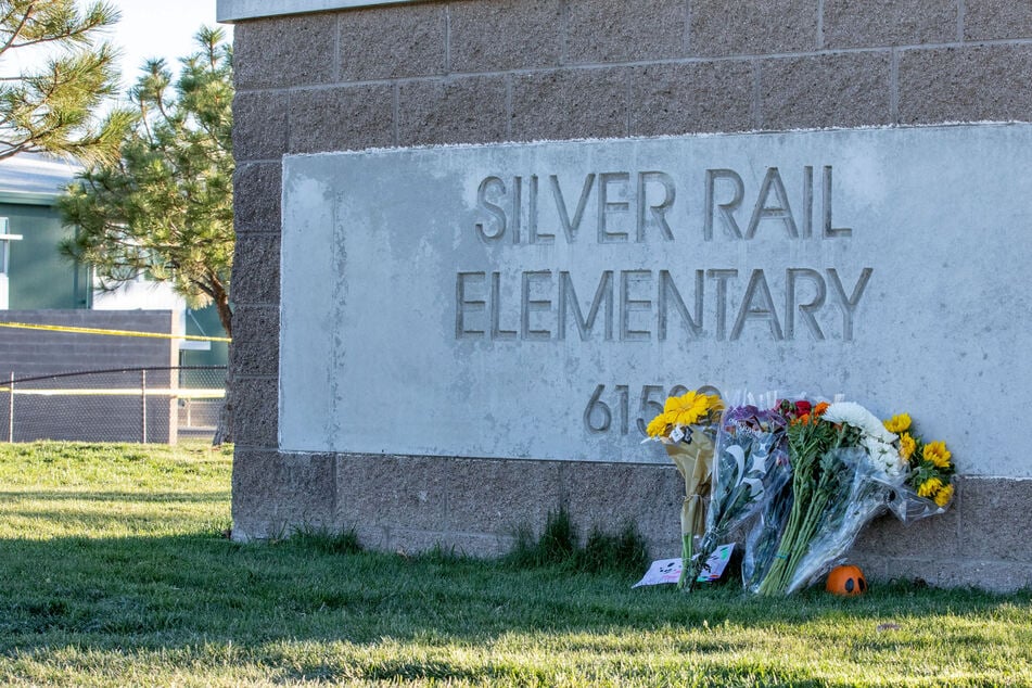 Flowers are placed at a sign a day after a shooting at Silver Rail Elementary School in Bend, Oregon, on Friday. Three children and a teacher were killed in the horrific attack.
