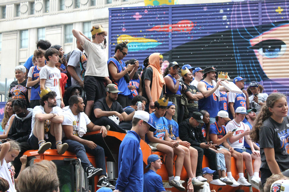 Knicks fans climbed atop garbage trucks and other vehicles in order to get a better view.