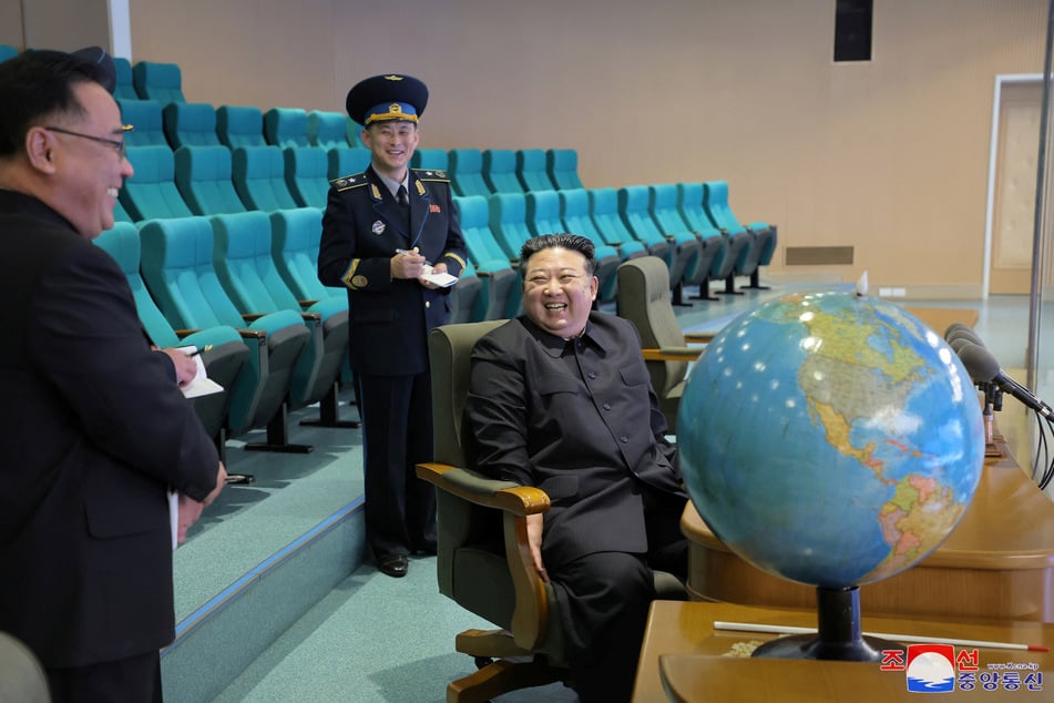 North Korean state media said the country's new spy satellite allowed leader Kim Jong-un (c.) to study images of the White House and Pentagon.