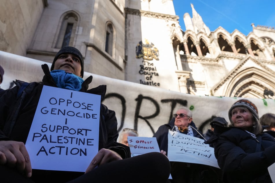 Protesters take part in a demonstration in support of Defend Our Juries and their campaign against the ban on Palestine Action, outside the Royal Courts of Justice in central London on November 26, 2025.
