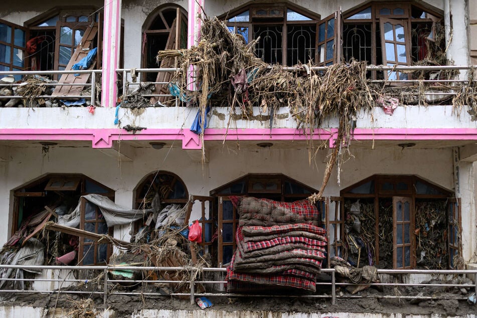 Debris is seen hanging out of the windows of a damaged house in the aftermath of flash floods at Devighat in Nepal's Nuwakot district on August 29, 2026.