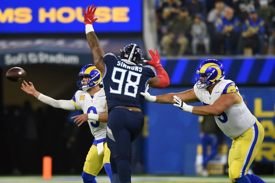 Rams quarterback Matthew Stafford (l) throws under pressure from Tennessee Titans defensive tackle Jeffery Simmons (c).