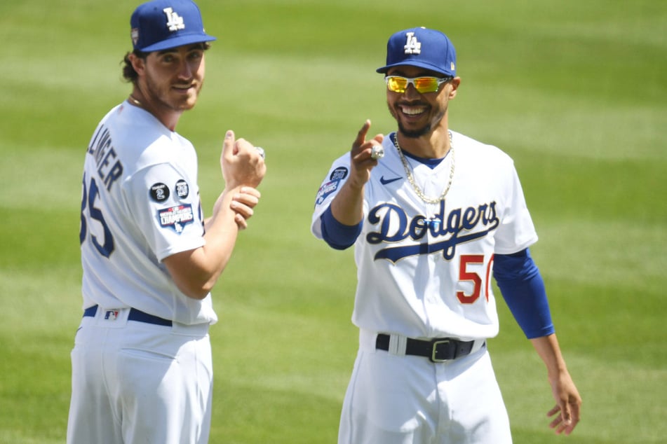 Cody Bellinger (l), (35) and teammate Mookie Betts (r), (50) show off their World Series rings