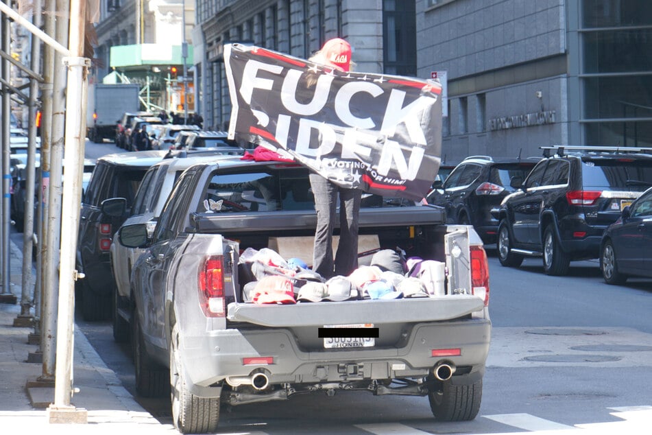 One Trump supporter danced in the bed of her truck while holding a "f**k Biden" flag.