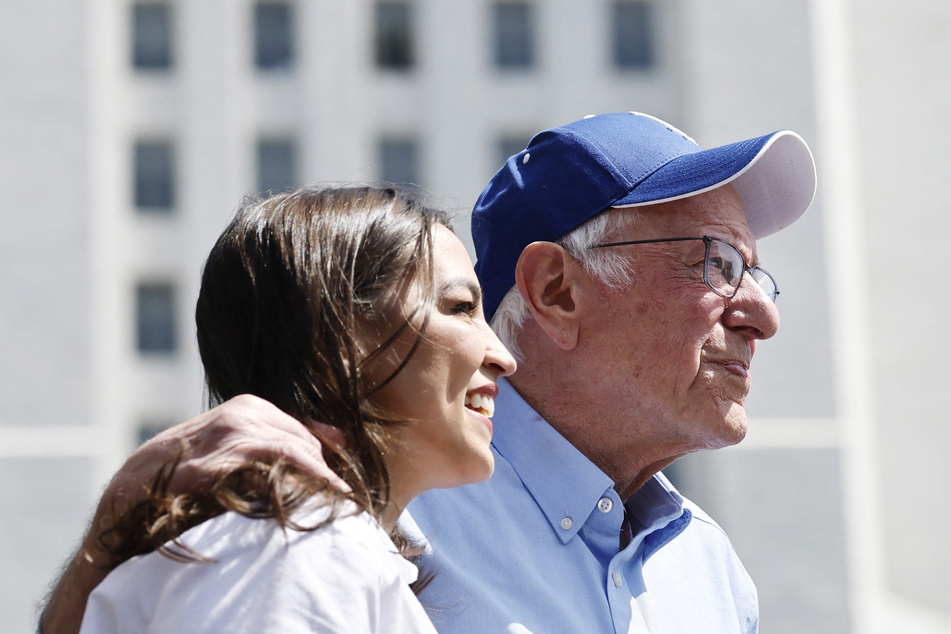 Senator Bernie Sanders (r.) and Representative Alexandria Ocasio-Cortez look toward the crowd during a stop on their "Fighting Oligarchy" tour in Los Angeles, California.