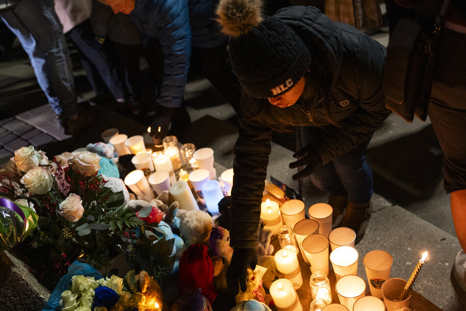 Members of the community lay flowers in honor of the victims of a school shooting in February that claimed the lives of eight people at Tumbler Ridge.