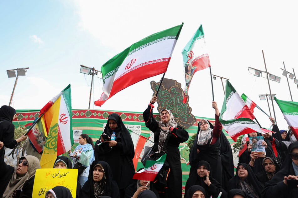 People wave Iranian flags during a rally to show their solidarity and support to the new supreme leader Ayatollah Mojataba Khamenei in Tehran on April 29, 2026.