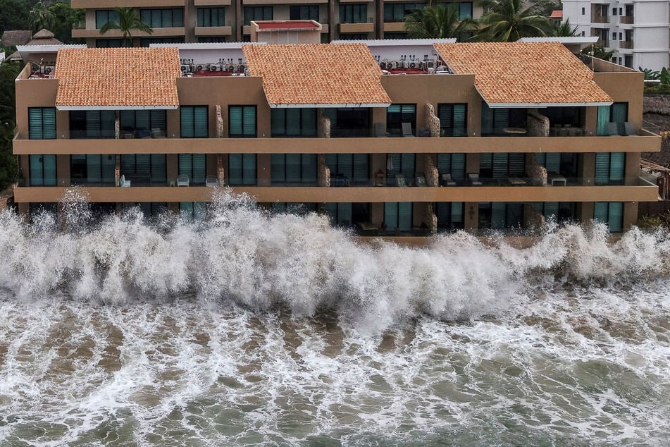 Waves crash against beachfront buildings as Hurricane Simon remains off Mexico's Pacific coast, in San Francisco, Bahia de Banderas, Nayarit state, on October 12, 2026.