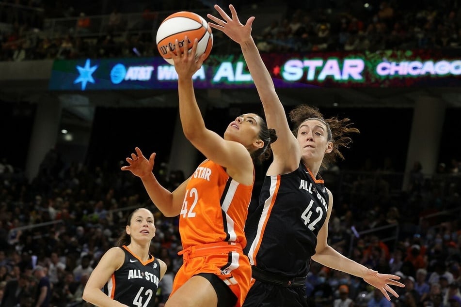 Kelsey Plum (l) drives to the basket against Breanna Stewart (r) during the 2022 AT&T WNBA All-Star Game.