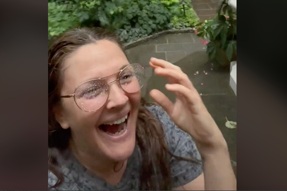 Drew Barrymore enjoys the rain as if she were a little kid.