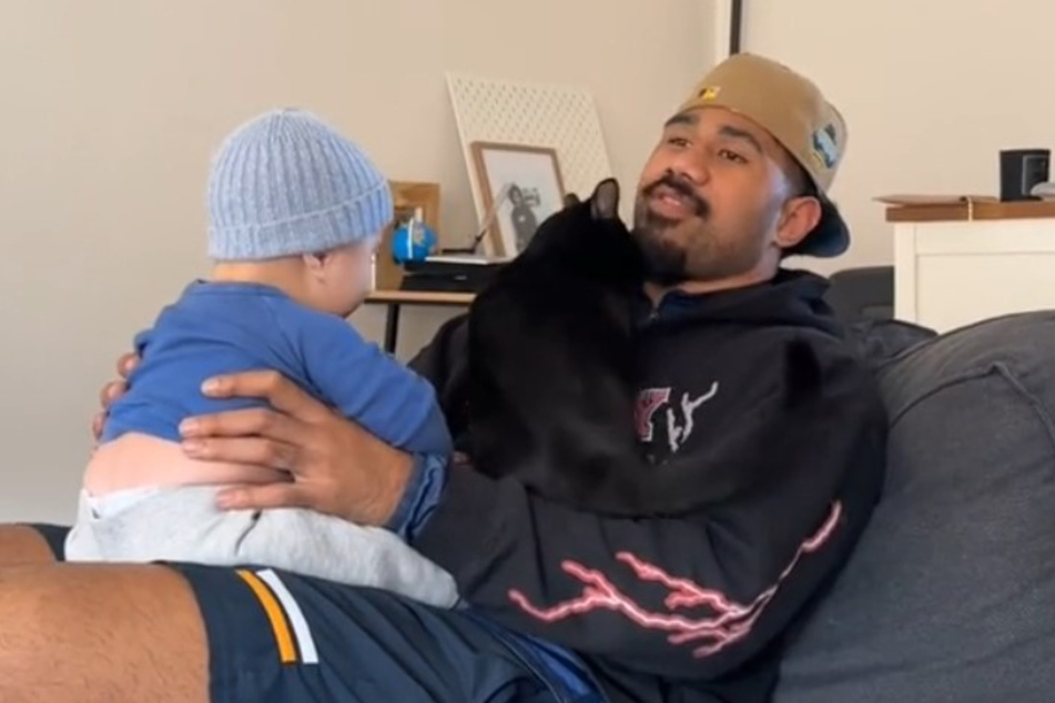 Komiti Tuilagi (r.) and son Tavini were trying to share a moment, but the cat refuses to be ignored!