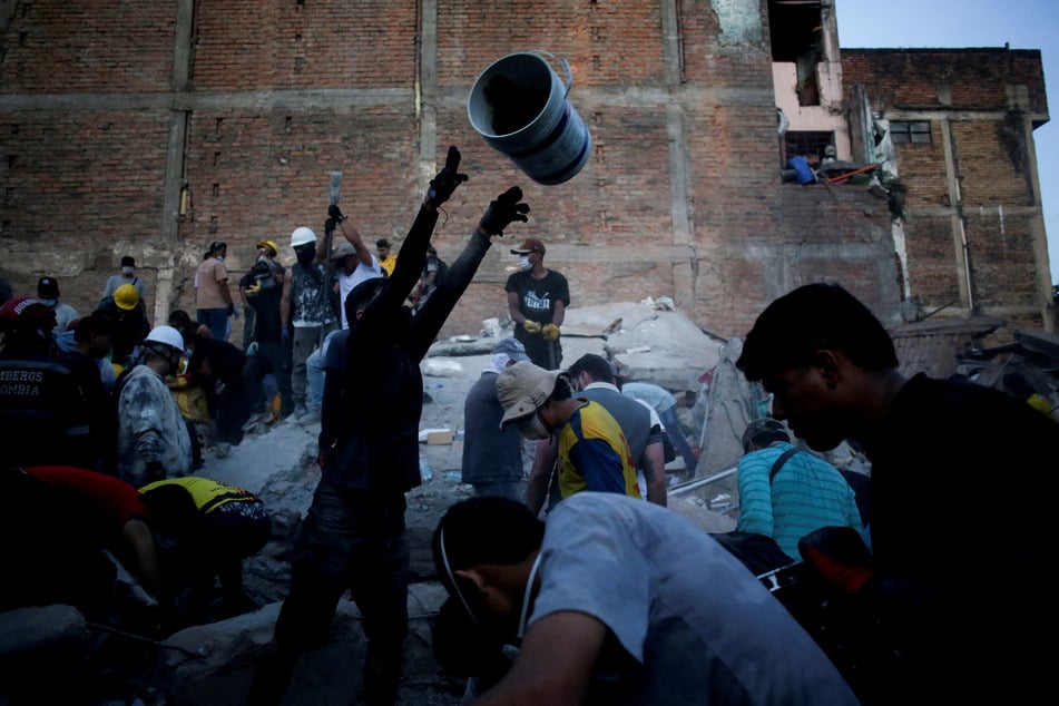 People work to clear debris at the site of a building damaged in an earthquake, in Pereira, Colombia, on August 11, 2026.