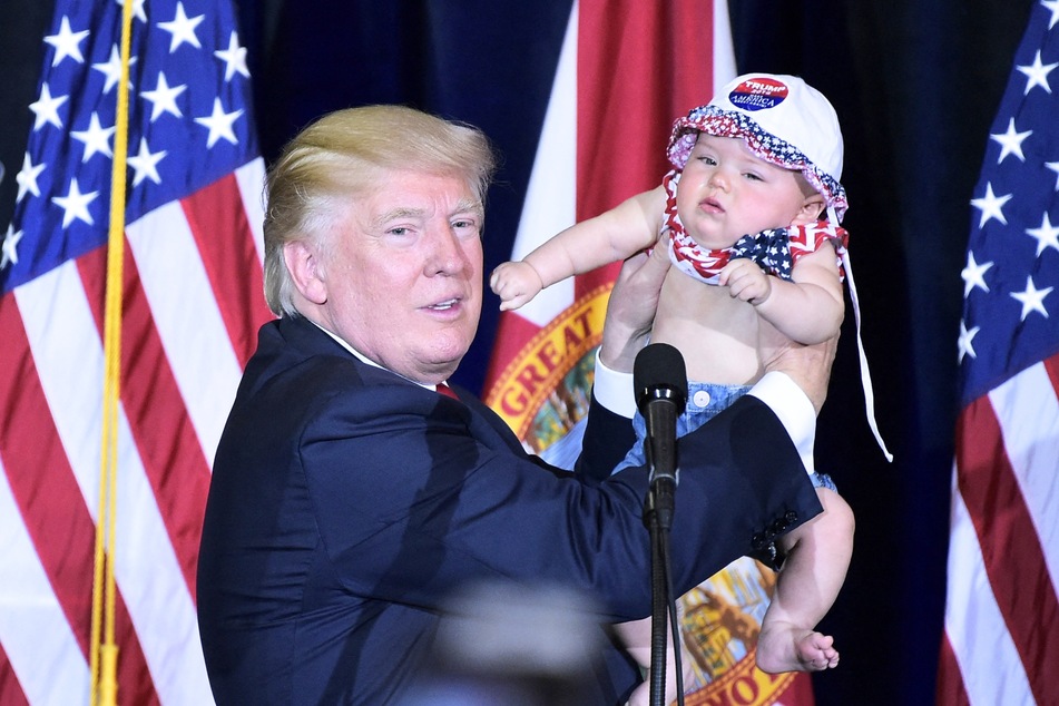 Then-presidential candidate Donald Trump holding a baby during a rally at the Special Events Center of the Florida State Fairgrounds in Tampa, Florida on November 5, 2016.