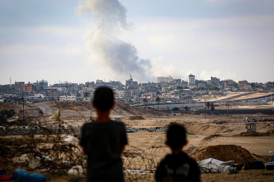 Boys watch smoke billowing during Israeli strikes east of Rafah in the southern Gaza Strip.