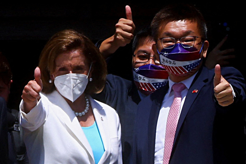 Pelosi gives a thumb's up next to Legislative Yuan Vice President Tsai Chi-chang as she leaves the parliament in Taipei, Taiwan.
