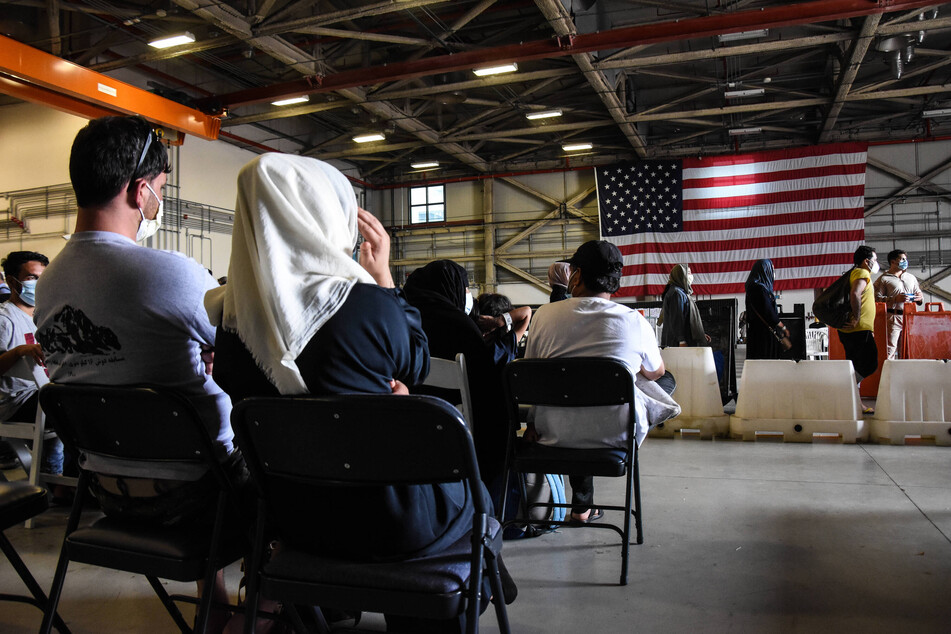 Afghan refugees sit at the NAS Sigonella transit site in Sicily, Italy, as they await transportation to the United States of America.