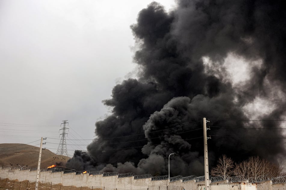 A smoke plume rises from an ongoing fire following an overnight airstrike on the Shahran oil refinery in northwestern Tehran on Sunday.
