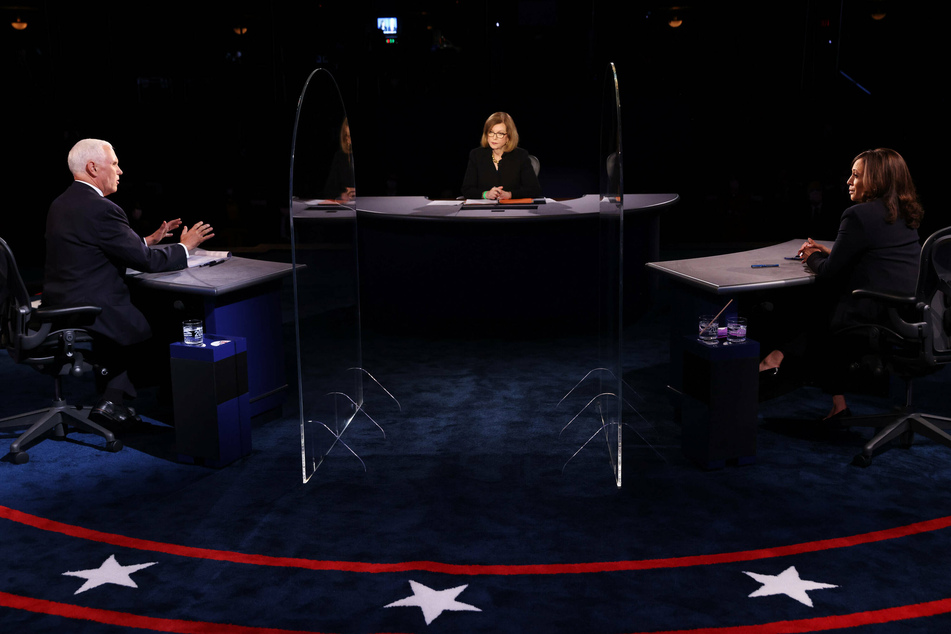Vice President Mike Pence (l.) and Kamala Harris debate each other from behind two plexiglass screens.