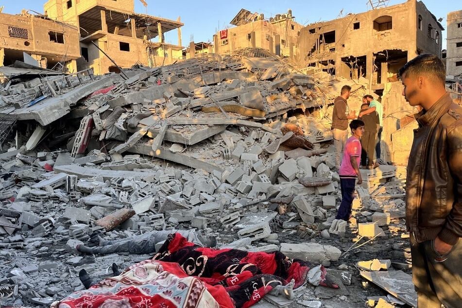 The bodies of victims recovered from the rubble of a building are covered with blankets on November 17, 2024, following an overnight Israeli strike in Beit Lahia in the northern Gaza Strip.