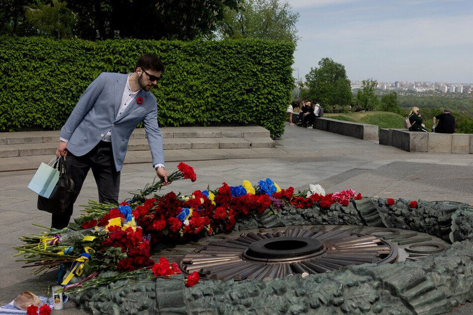 A man lays a flower bouquet on the Tomb of the Unknown Soldier at the WWII memorial on the 81st anniversary of Victory in Europe Day in Kyiv, Ukraine, on May 8, 2026.